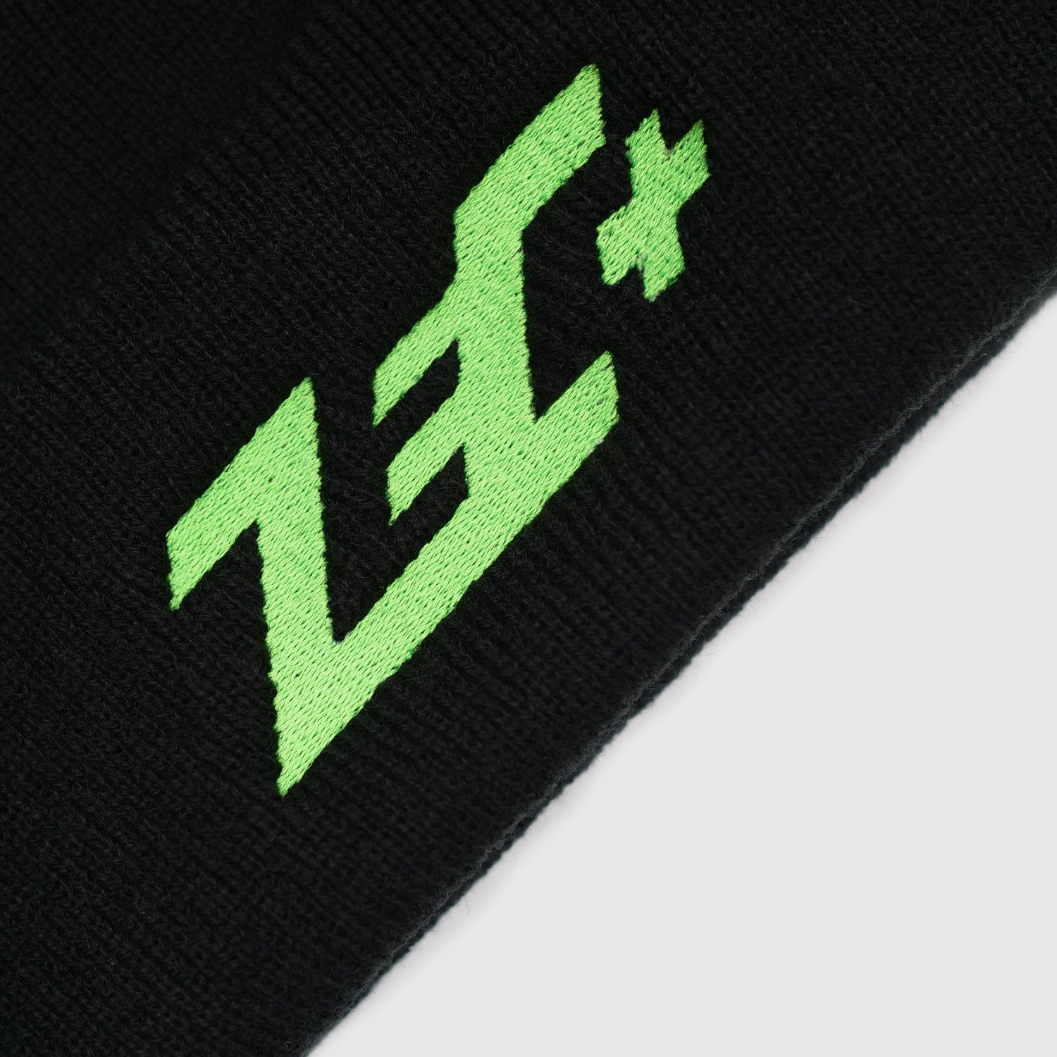 Detailansicht grüne Logo-Stickerei auf schwarzer Beanie