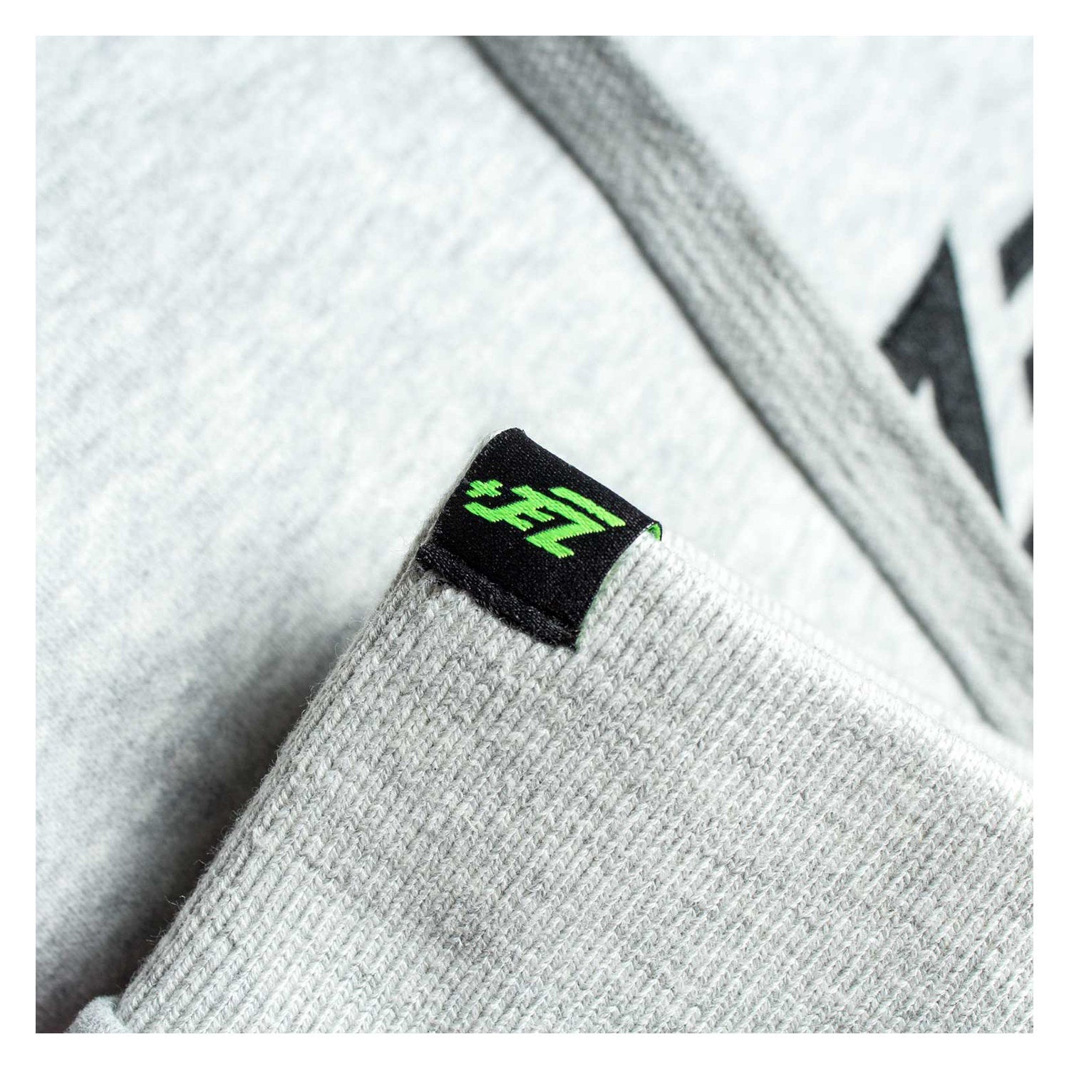Detailansicht Zec+ Logo-Etikett am Ärmel des grauen Hoodies